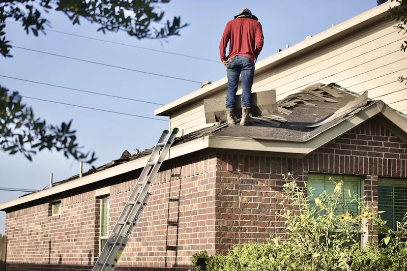 Professional roofer working on a residential roof in Adams Crossroads